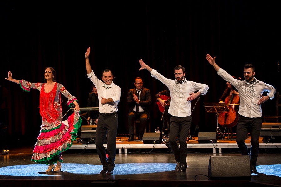Flamenco-Tanzpaar mit Musik-Ensemble und Gruppentänzern